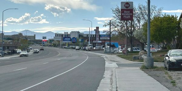 Street view with cars and hotel signs.