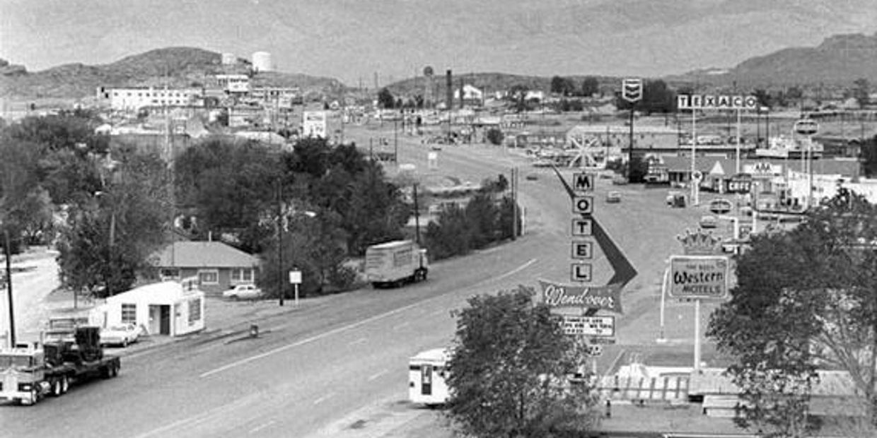 Black and white photo of a highway with motels and gas stations.
