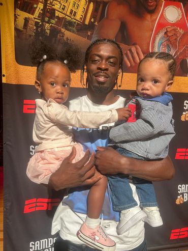 Man holding two young children at an ESPN event.