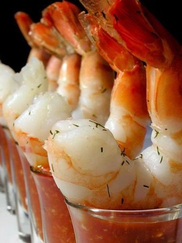 Close-up of shrimp cocktail glasses with shrimp and sauce.