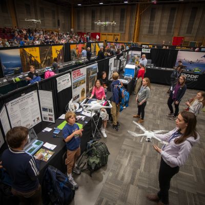 People explore drone technology exhibits at an indoor expo.