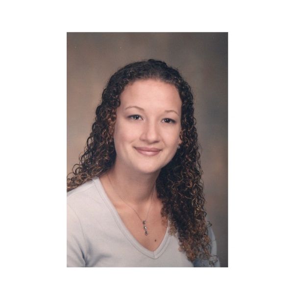 Young woman with curly hair smiling.