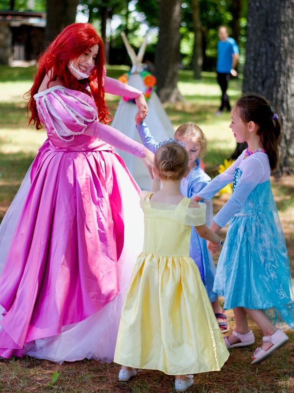Princesse anime des enfants costumés lors d'une fête d’enfants en plein air
