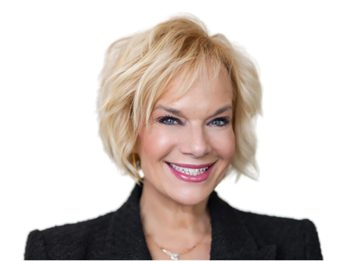 Smiling woman with blonde hair in a black blazer against a white background.