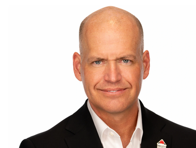 Confident man in a black suit with a pin on his lapel.