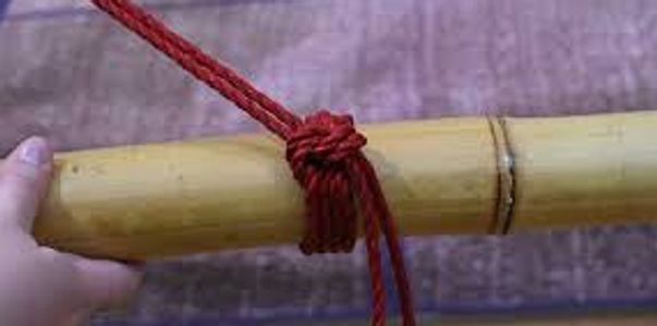 A piece of bamboo with a single column tie made with red rope.