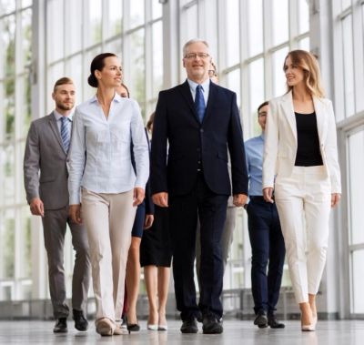 Group of confident business people walking in a modern office building.