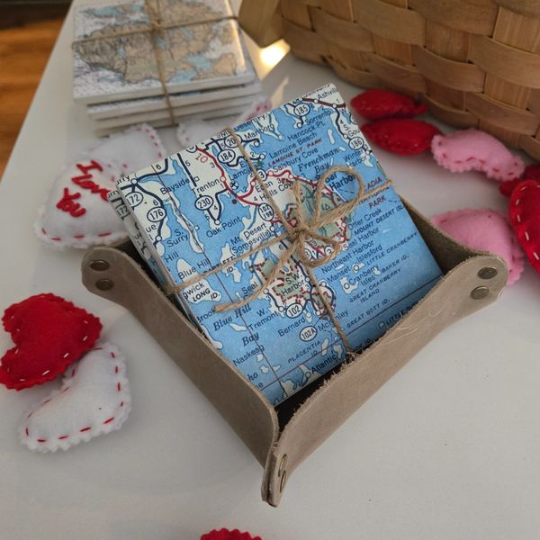 A set of Ceramic Coasters featuring a vintage map.  The coasters are in a leather coaster holder
