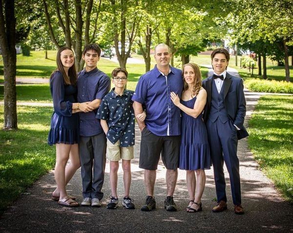 Une famille posant ensemble dans un parc.