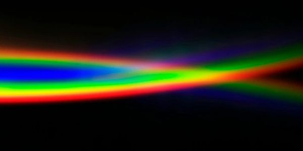 Colorful light beams crossing on a black background.
