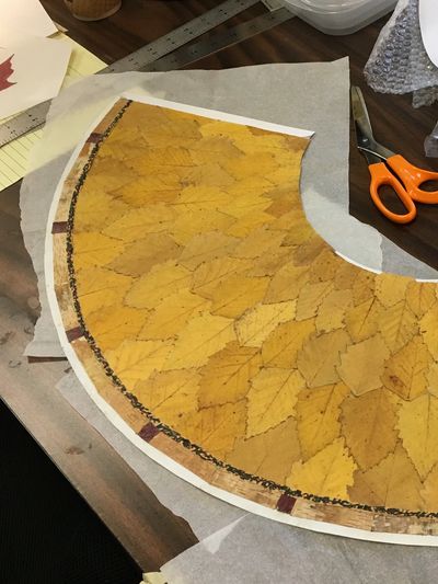 A completed arc—of river birch leaves and bark trim, with sumac accents—awaits forming.
