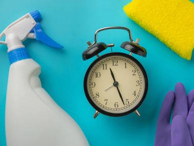 Cleaning supplies and clock on a blue background.