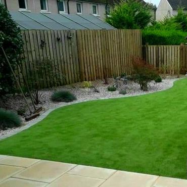 Artificial lawn with new planting and gravel chips