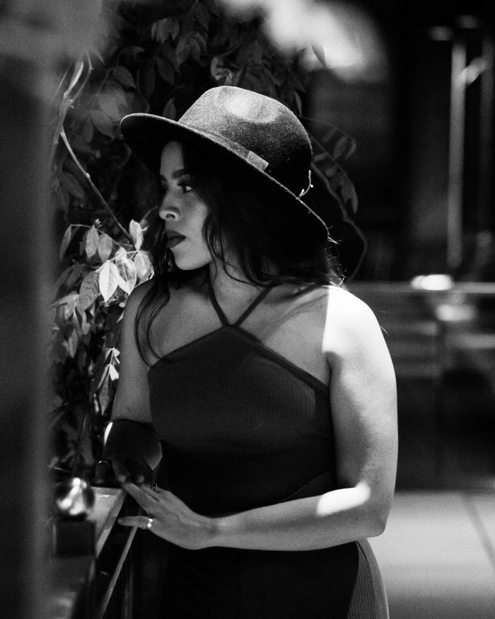 Woman in a hat gazing thoughtfully in black and white.