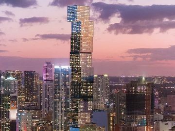 Tall, uniquely shaped skyscraper during sunset in a city skyline.