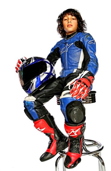 Young boy in studio portrait dressed in motocross gear