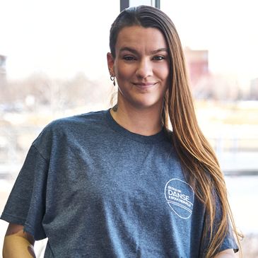 Personne souriante avec un t-shirt "École de Danse" et bracelets.
