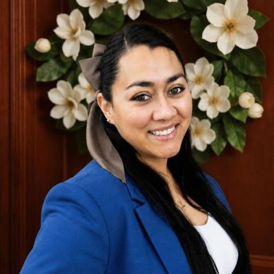 Woman smiling with floral background.