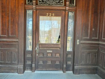 Ornate wooden door with the number 725 and stained glass panels.