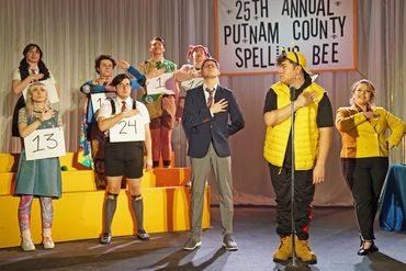 Contestants stand with hands over hearts at the 25th Annual Putnam County Spelling Bee stage.