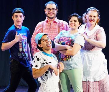 Cast of "The Perfect Dog" musical posing on stage with lively expressions.