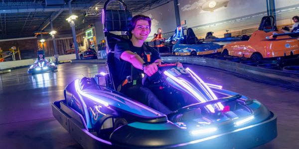 Person enjoying an indoor electric go-kart ride.