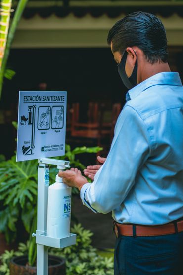 Hombre poniéndose gel sanitizante con el despachador de gel