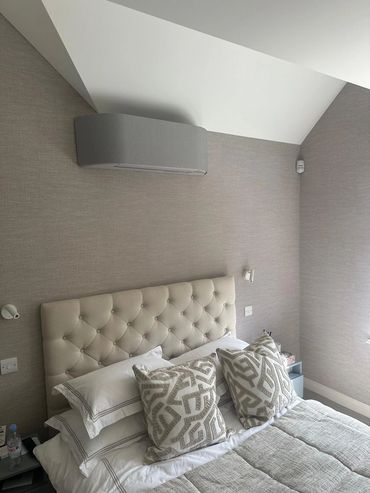 Cozy bedroom with a tufted headboard and patterned pillows.