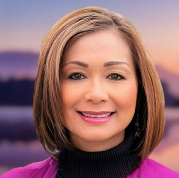 Smiling woman with short brown hair and pink lipstick.