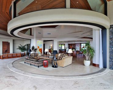 Luxurious open living space with circular ceiling and modern furniture.