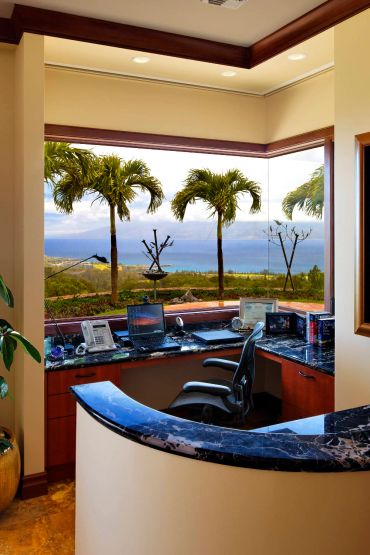 Office workspace with ocean view through large windows.