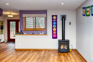 Cozy room with wood stove and colorful wall hangings.