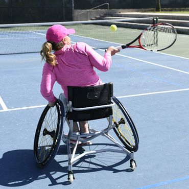 tennis player in wheelchair playing tennis with racquet