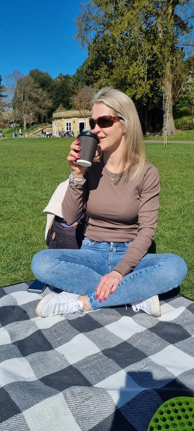 Woman enjoying coffee on a sunny day in the park.