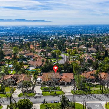 Residential neighborhood with houses and trees under a blue sky.
