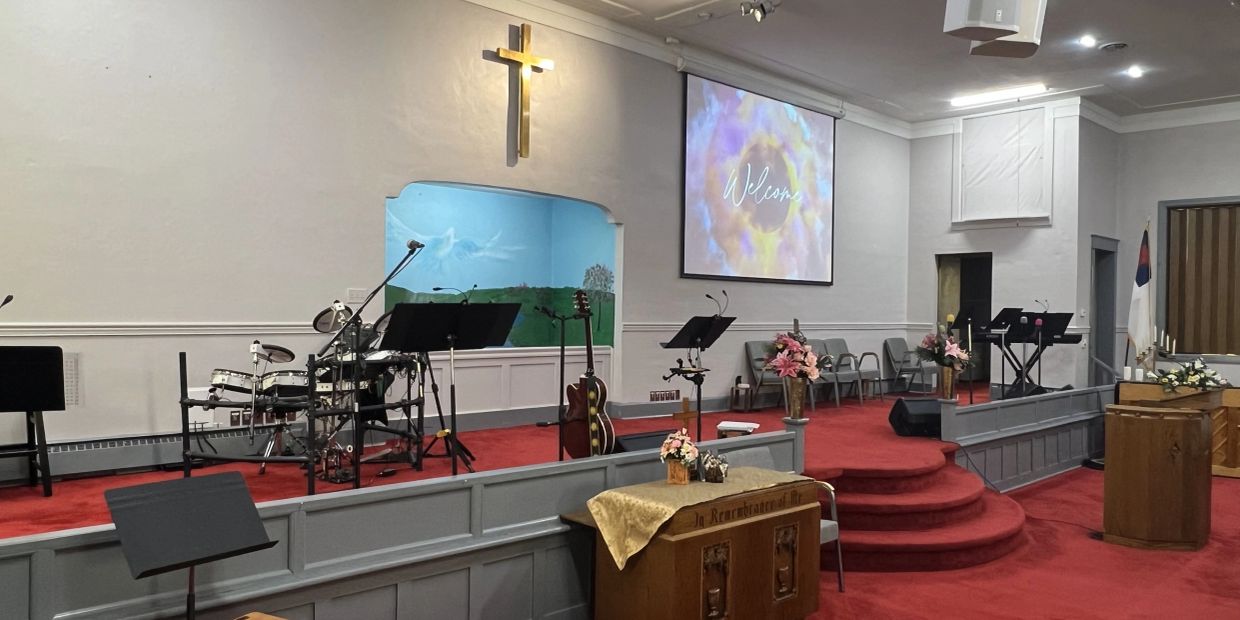 Interior of a church sanctuary with musical instruments and a cross.