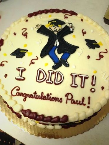 A cream colored graduation cake to Paul