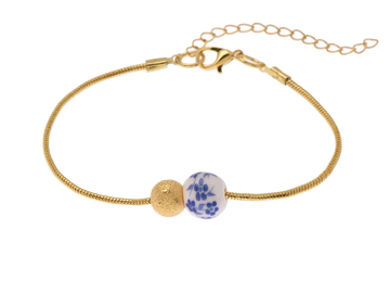 Delicate gold bracelet with a textured bead and a blue floral ceramic bead.