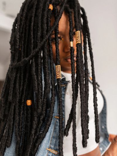 beautiful woman with long faux locs peers from behind hair