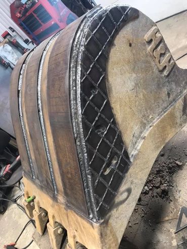 A heavy-duty excavator bucket with reinforced metal welding.