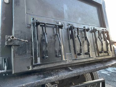 Close-up of a heavy-duty truck tailgate with multiple locking mechanisms.