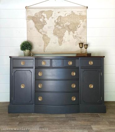 Dark blue vintage dresser with gold handles and a world map above.