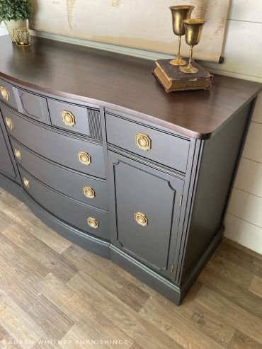 Elegant black and wood dresser with gold accents.