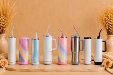 Colorful and stainless steel travel tumblers lined up on a wooden tray.