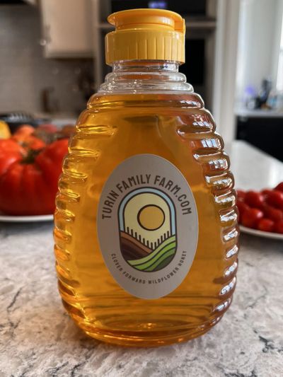 A honey bottle from Turm Family Farm on a kitchen counter.