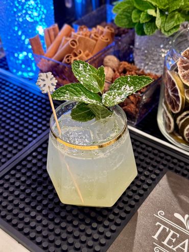 Refreshing mint cocktail with a snowflake stirrer and powdered garnish.