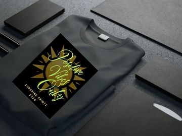 Black t-shirt with a golden sun and stylish text design.