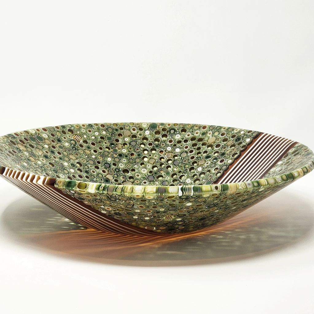 Decorative glass bowl with intricate patterns and earthy colors.