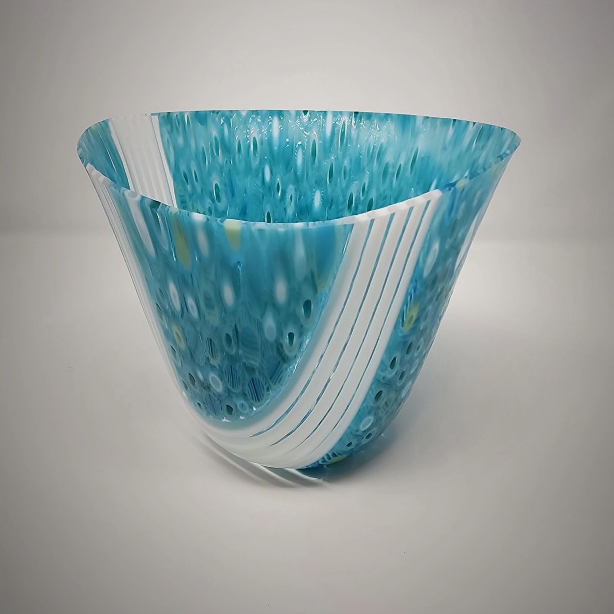 Handcrafted blue and white glass bowl with wavy design.