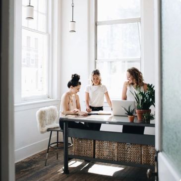 Three woman sitting at a table and talking